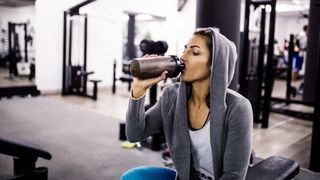 Woman drinking a protein shake in gym