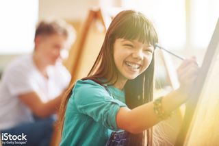 Young girl painting a canvas, from iStock
