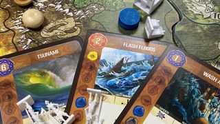 A collection of cards from Spirit Island laid out on the board with tokens and models