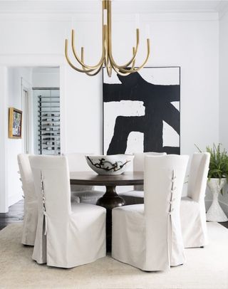 White dining room with circular table and white chairs