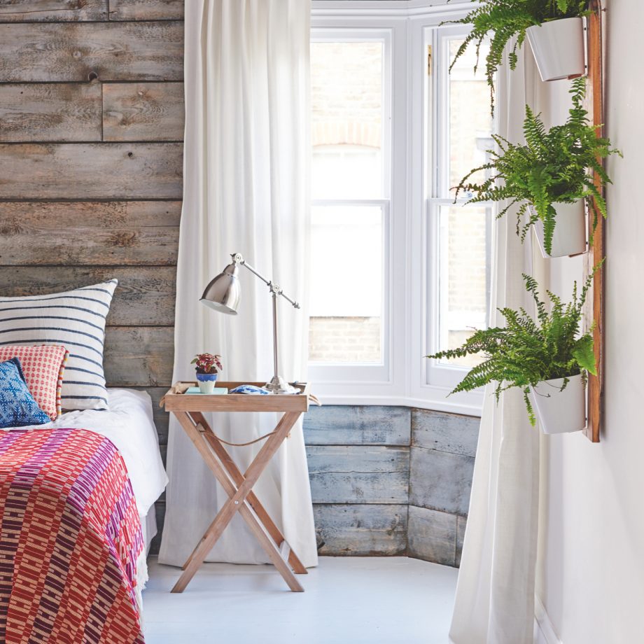 bedroom with wooden wall cladding and house plants