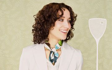 Woman Holding a Fly Swatter With a Dead Fly on it