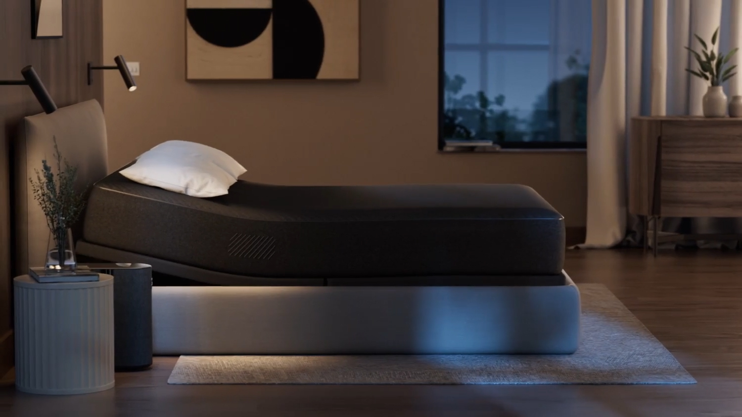 The Eight Sleep Pod 4 Ultra cover and base on a bed in a bedroom, with a slight elevation at the head of the mattress
