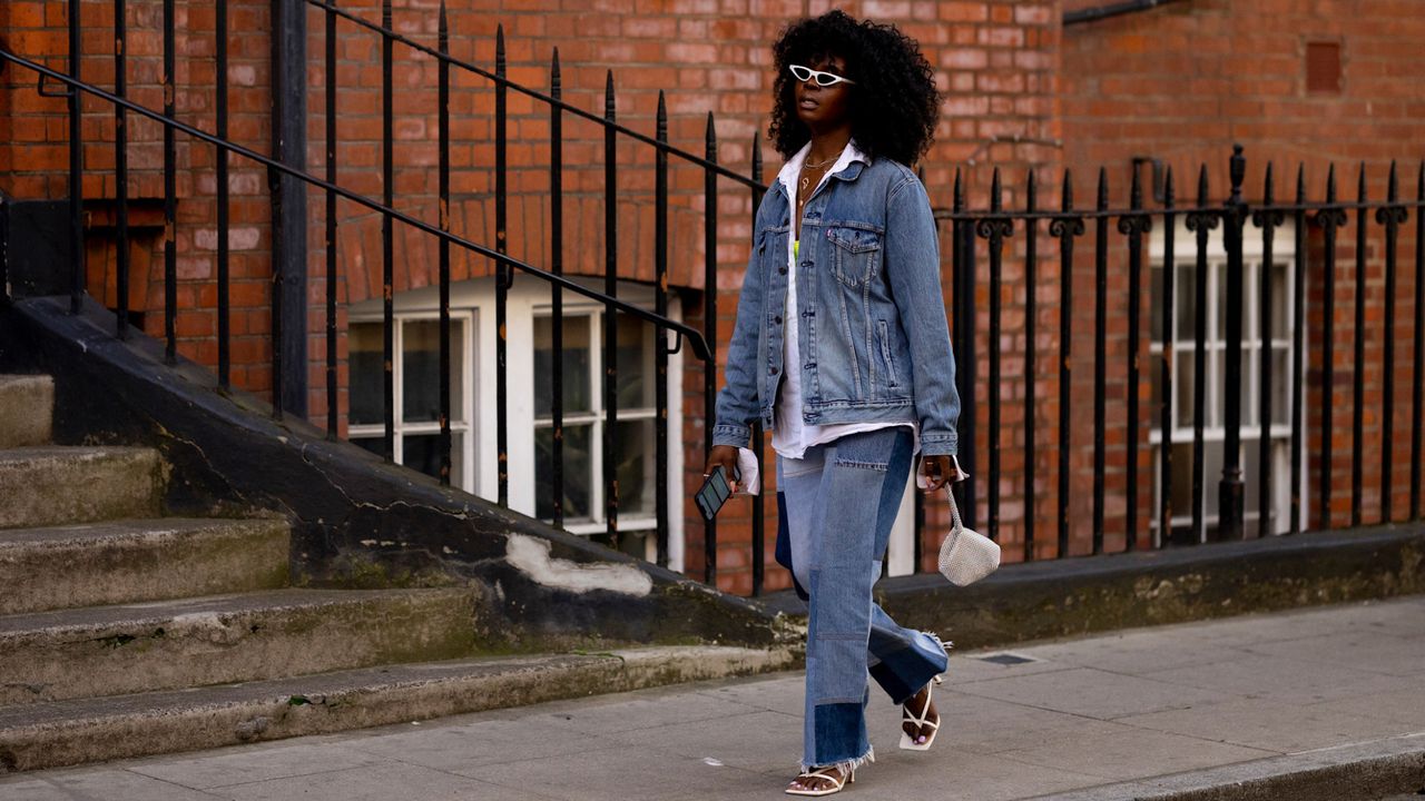 London spring fashion week attendee wearing a jean jacket and jeans and white button down shirt 