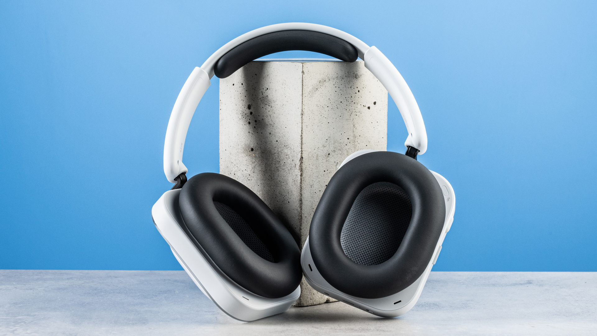 the nothing headphone (a) photographed against the blue tom's guide background, showing the transparent and white ear cups with red accents, the padded headband, and the accessories including 3.5mm jack