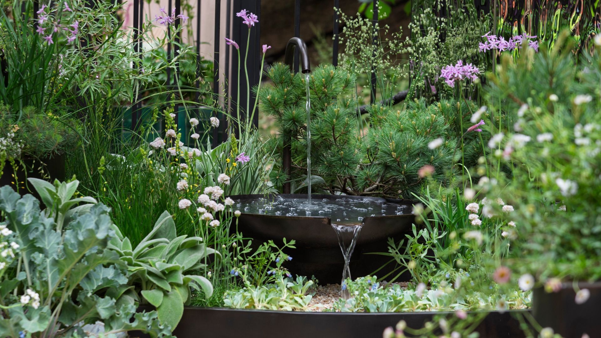 A water feature in a garden surrounded by flowers