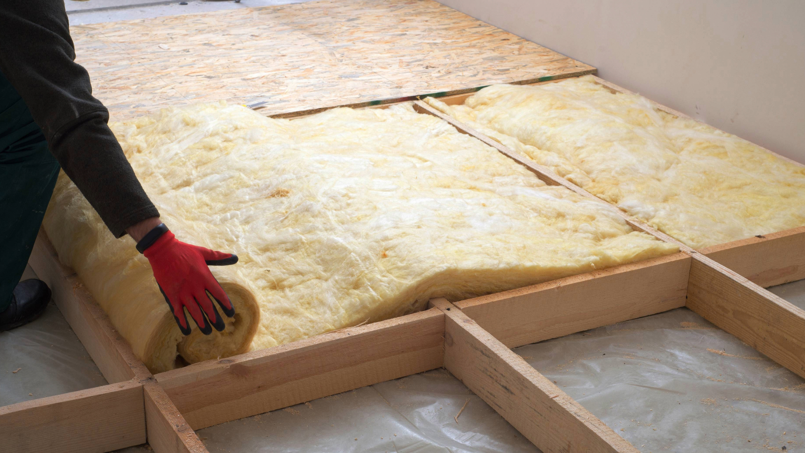 Hand rolling insulation into a wooen frame