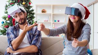 To julepyntede VR-brukere i en sofa.
