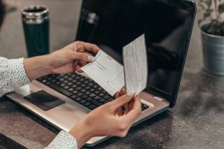 Hands holding a check and deposit slip