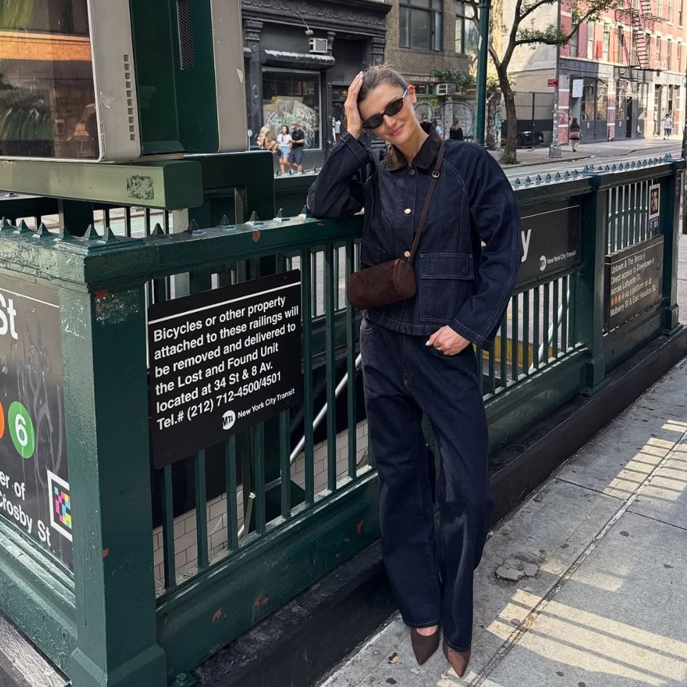 Influencer @cocoschiffer wears a denim two-piece with brown satin heels and a brown suede cross-body bag.