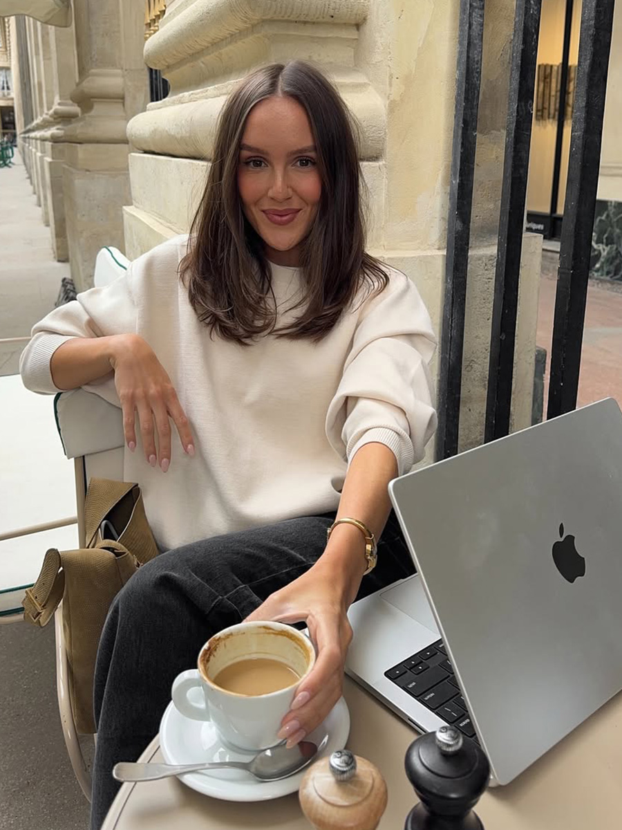 Emma Leger drinks coffee while working at a cafe in Paris.