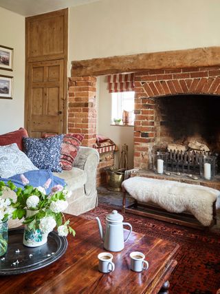 farmhouse living room with brick fireplace, wooden doorway and sofas