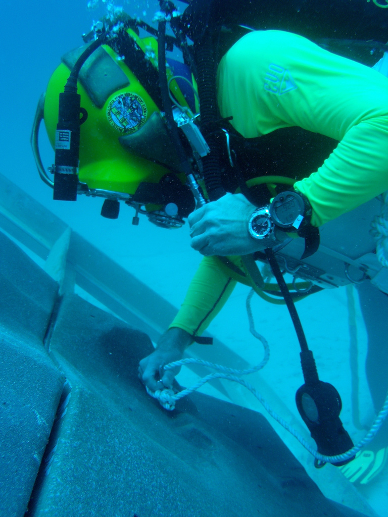 A diver anchoring to a simulated asteroid surface created for NASA&#039;s underwater NEEMO 15 mission.