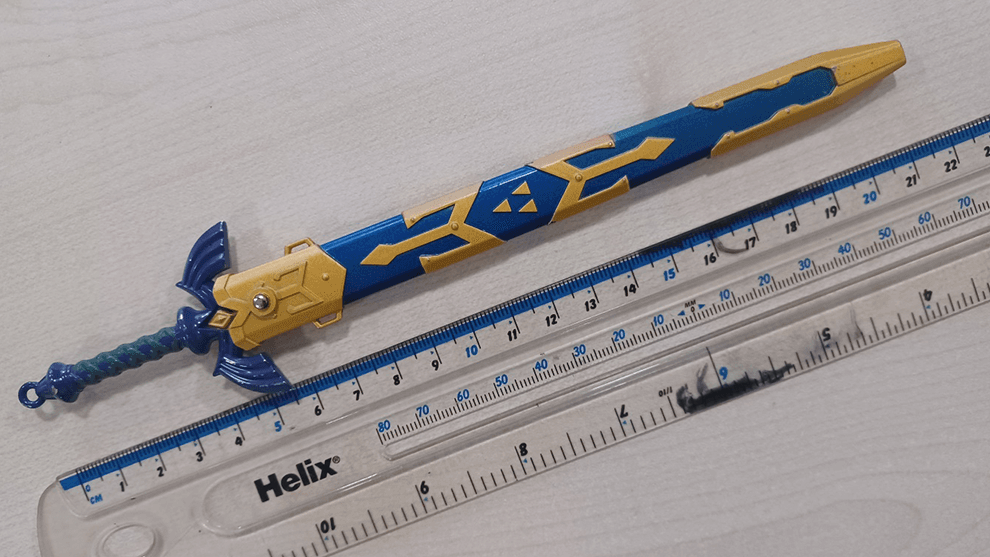 A small Master Sword replica compared against a ruler, measuring 6 inches.