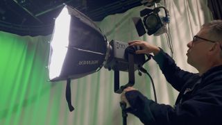 Neewer AS600B video light in a studio being adjusted by a person