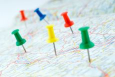Colorful pushpins marking points on a map.