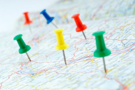 Colorful pushpins marking points on a map.