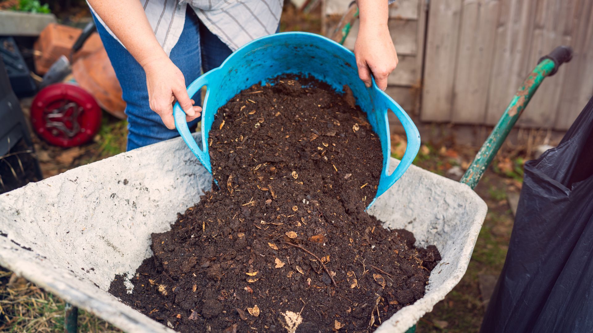 picture of woman pouring soil into wheelbarrow