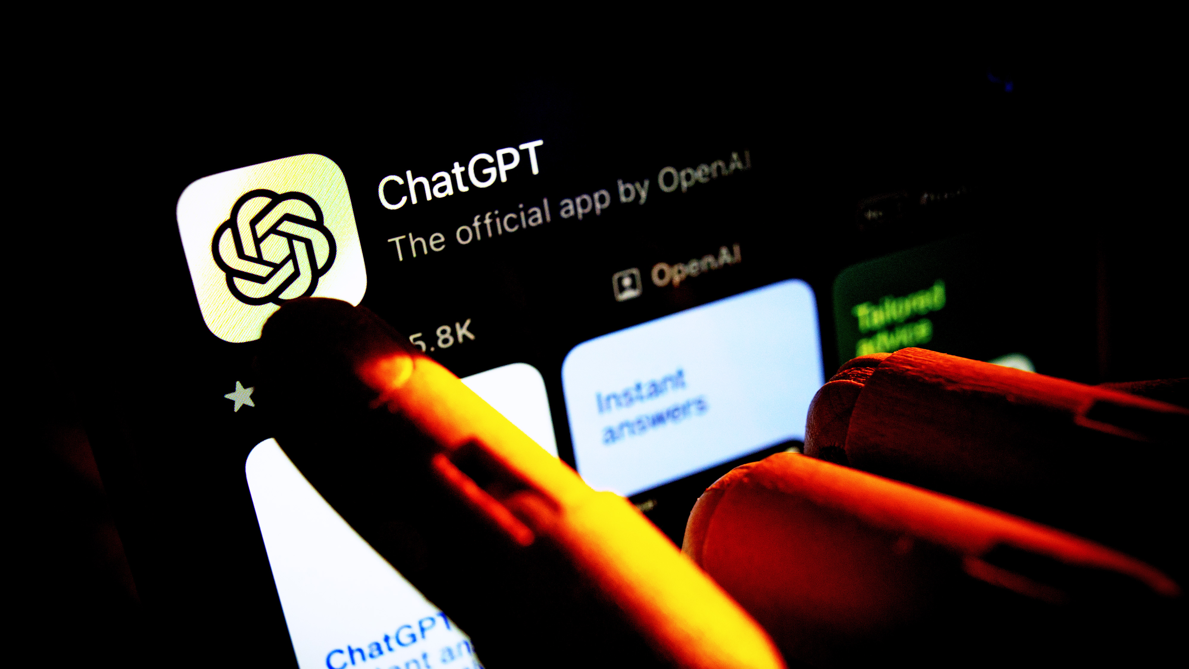 An artificial hand is seen pointing a finger onto a mobile phone screen displaying the Apple App Store with the Chat GPT app in this photo illustration on 29 October, 2023 in Warsaw, Poland. (Photo by Jaap Arriens/NurPhoto via Getty Images)
