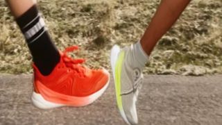 An orange running shoe and a grey and yellow running shoe