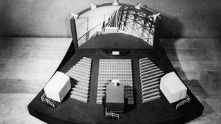 This image depicts a model of a Cinerama theatre with three projectors and a deeply curved screen