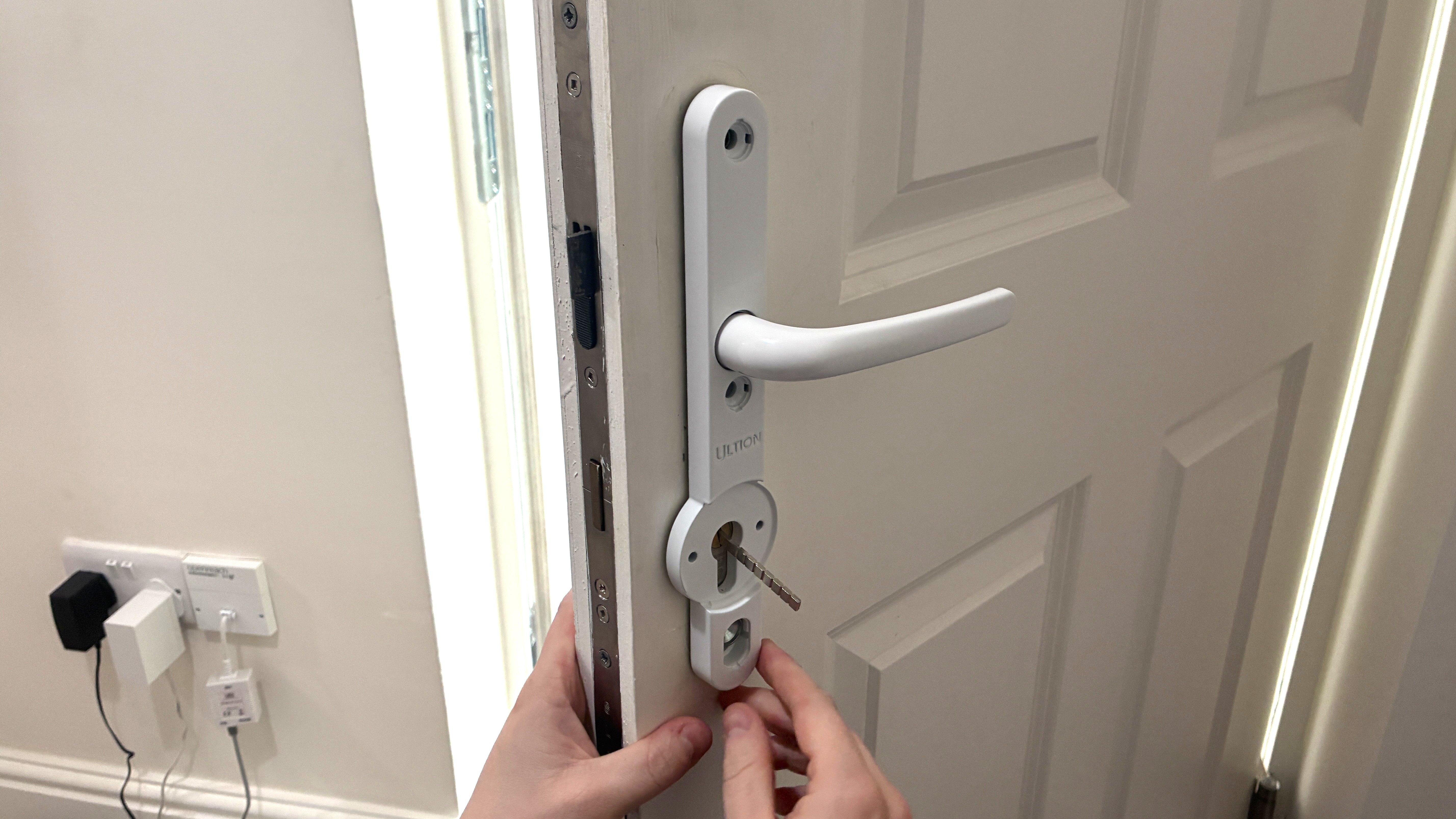 Person installing Ultion Nuki smart lock on door