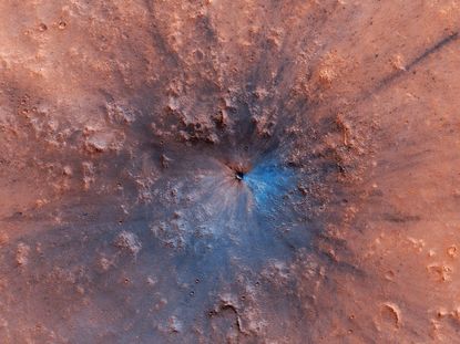 A new crater on Mars, which appeared sometime between September 2016 and February 2019, shows up as a dark smudge on the landscape in this high-resolution photo.