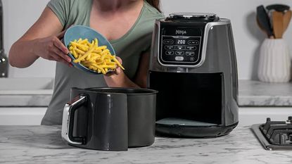 One of the items available on Amazon Prime Big Deal Days, the Ninja MAX XL, on countertop being used to cook fries