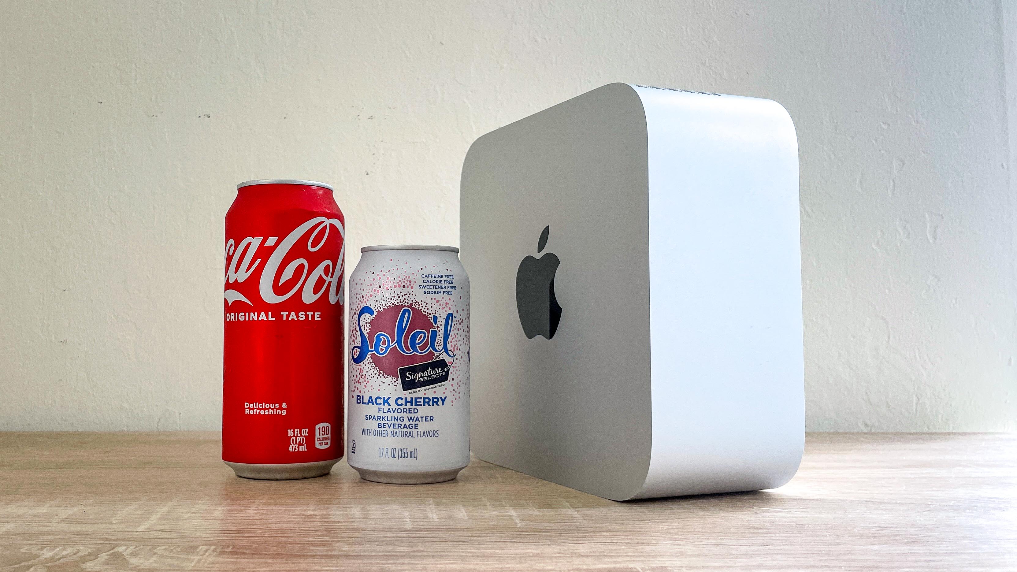 Mac Studio de pie de lado junto a latas de refresco