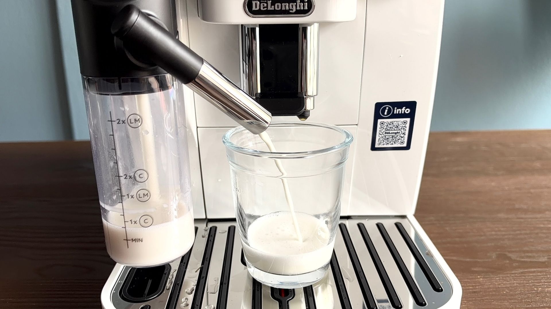 Milk pouring into glass cup from De'Longhi Magnifica Start
