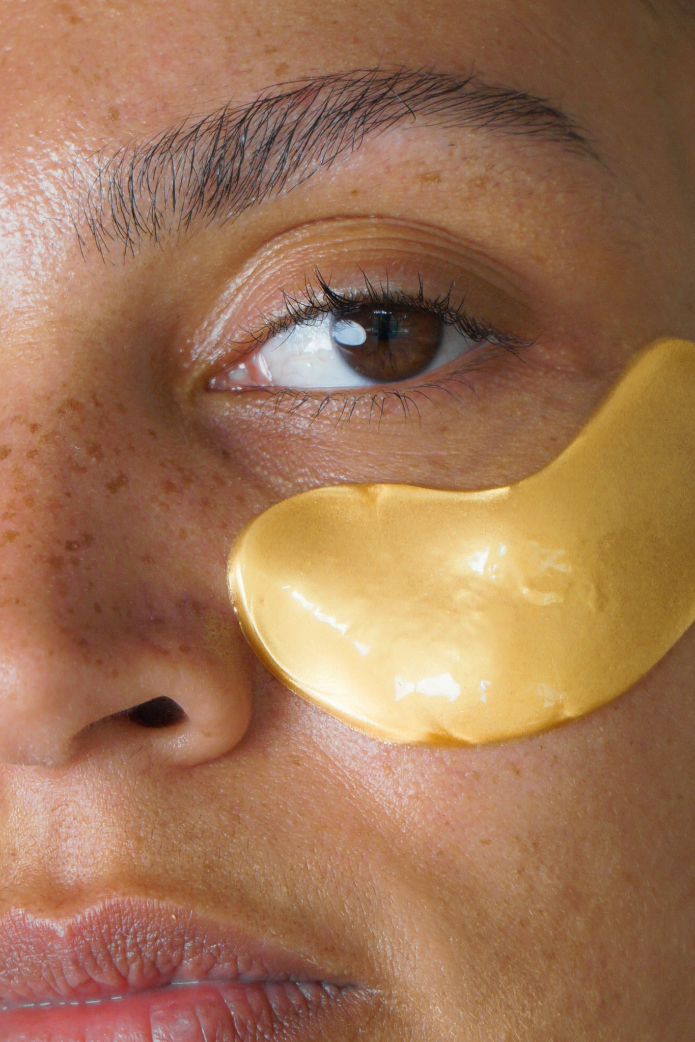 A close up of a model wearing an under-eye mask