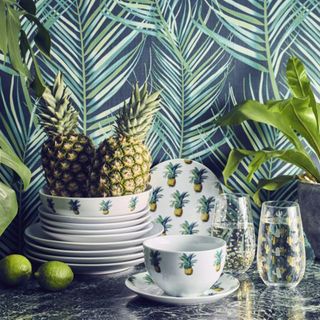 room with leaf printed walls pineapple printed dinnerwares and lemons