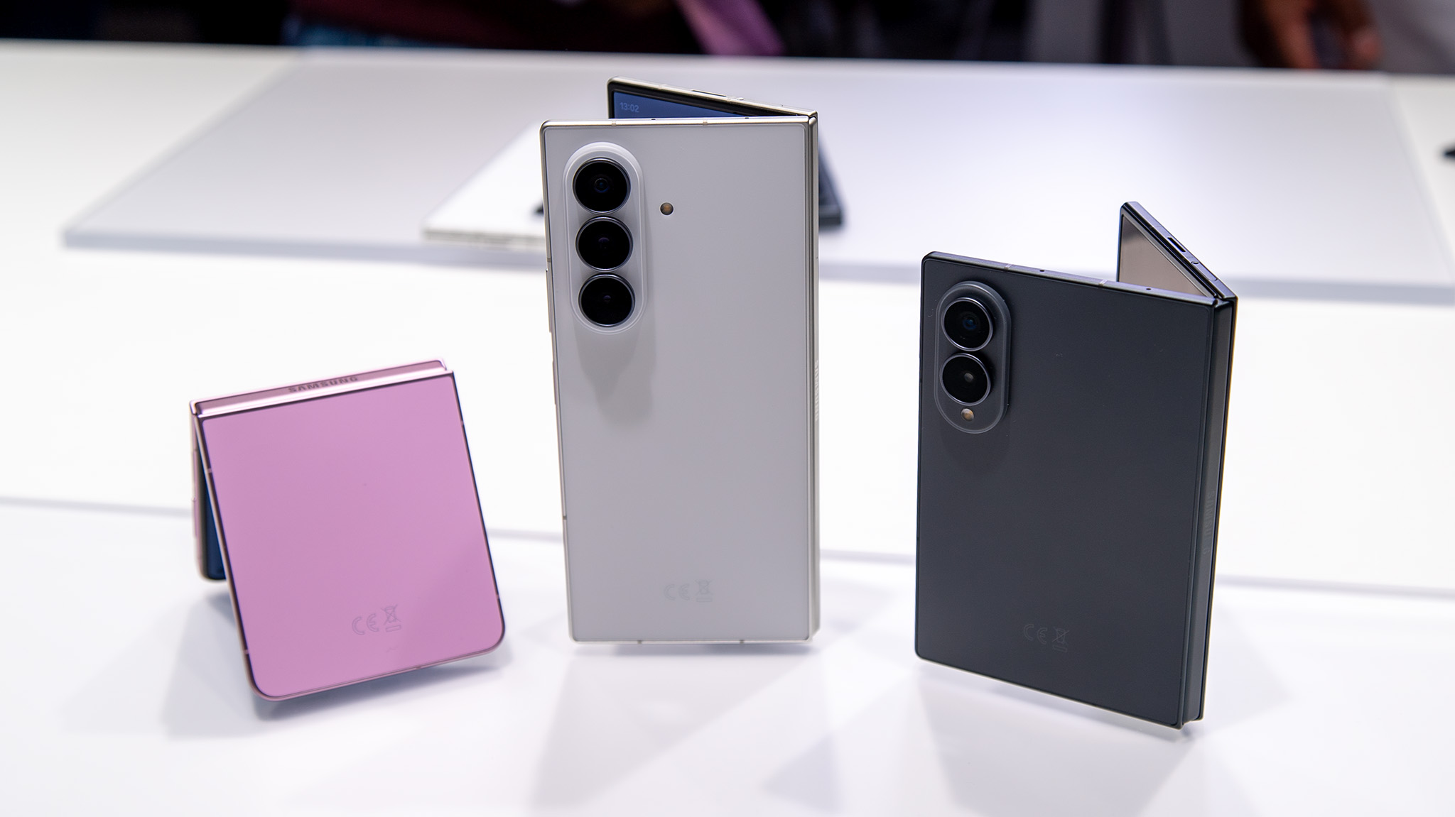 Comparing the sizes of the Samsung Galaxy Z Flip 8 (pink) with the white Galaxy Z Fold 8 Ultra and grey Galaxy Z Fold 8