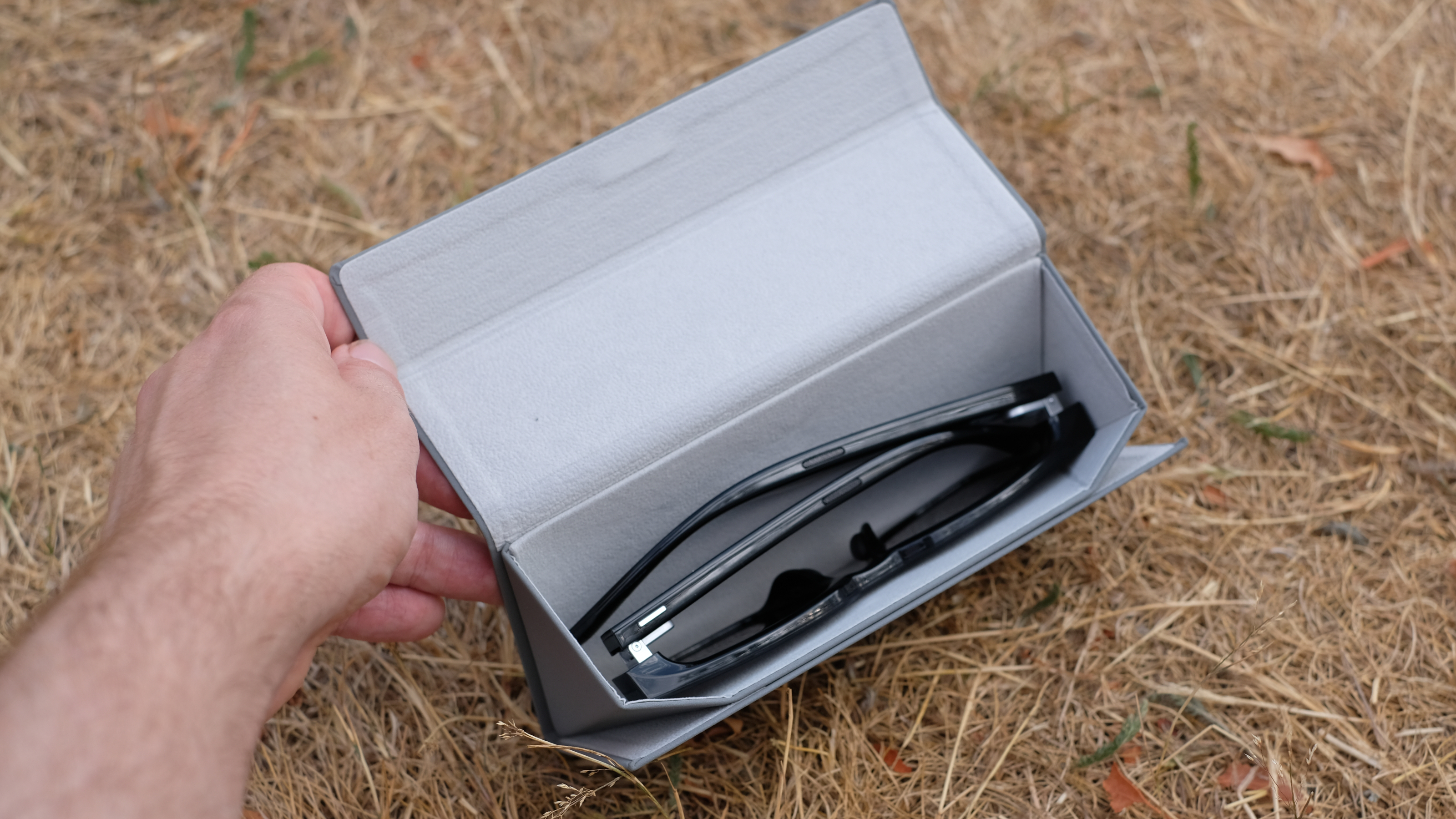 Hands-on photograph of Rokid AI Glasses Style inside grey case
