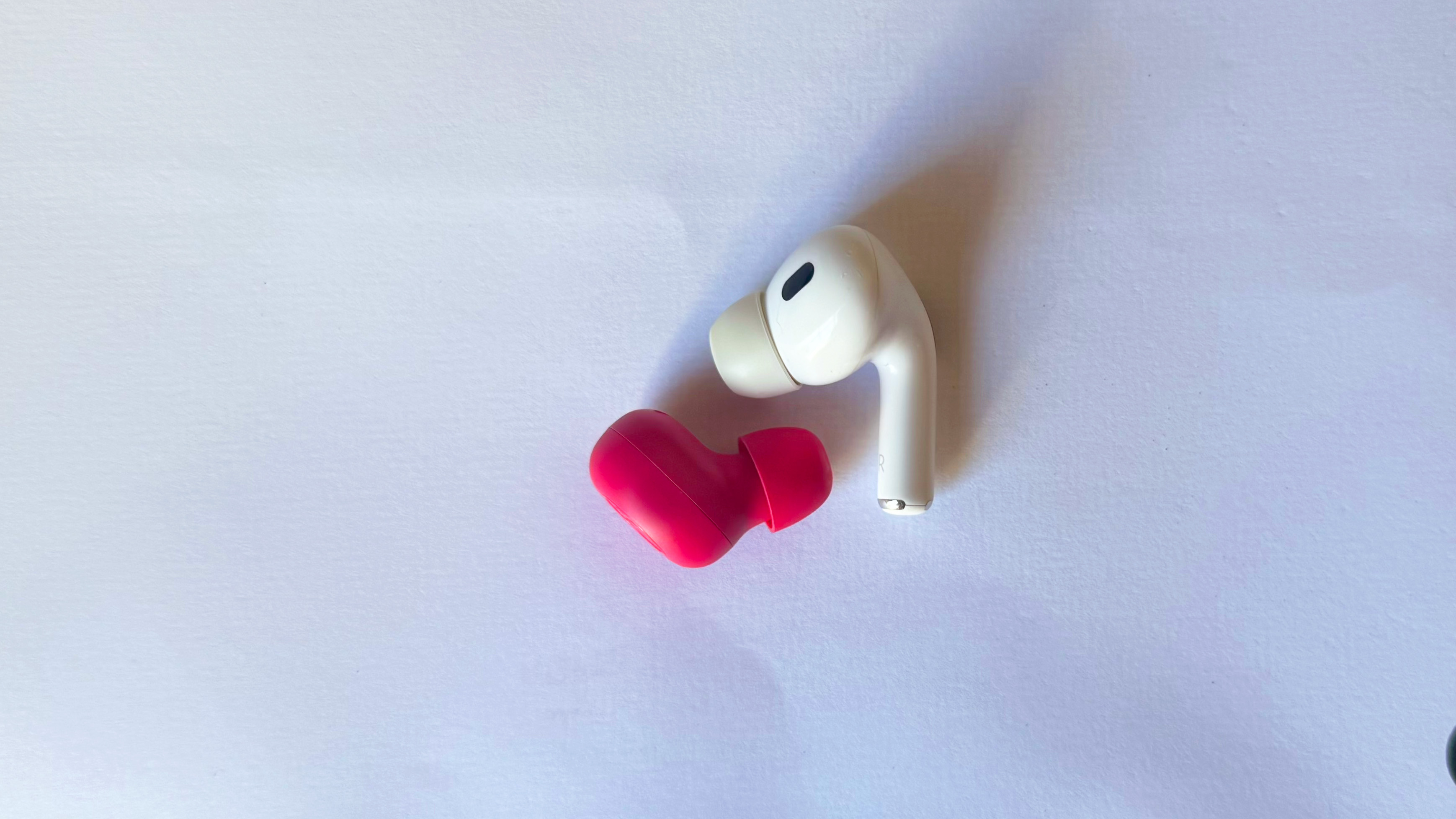 the jlab jbuds mini and apple airpods pro 2 comparison photo in a white background