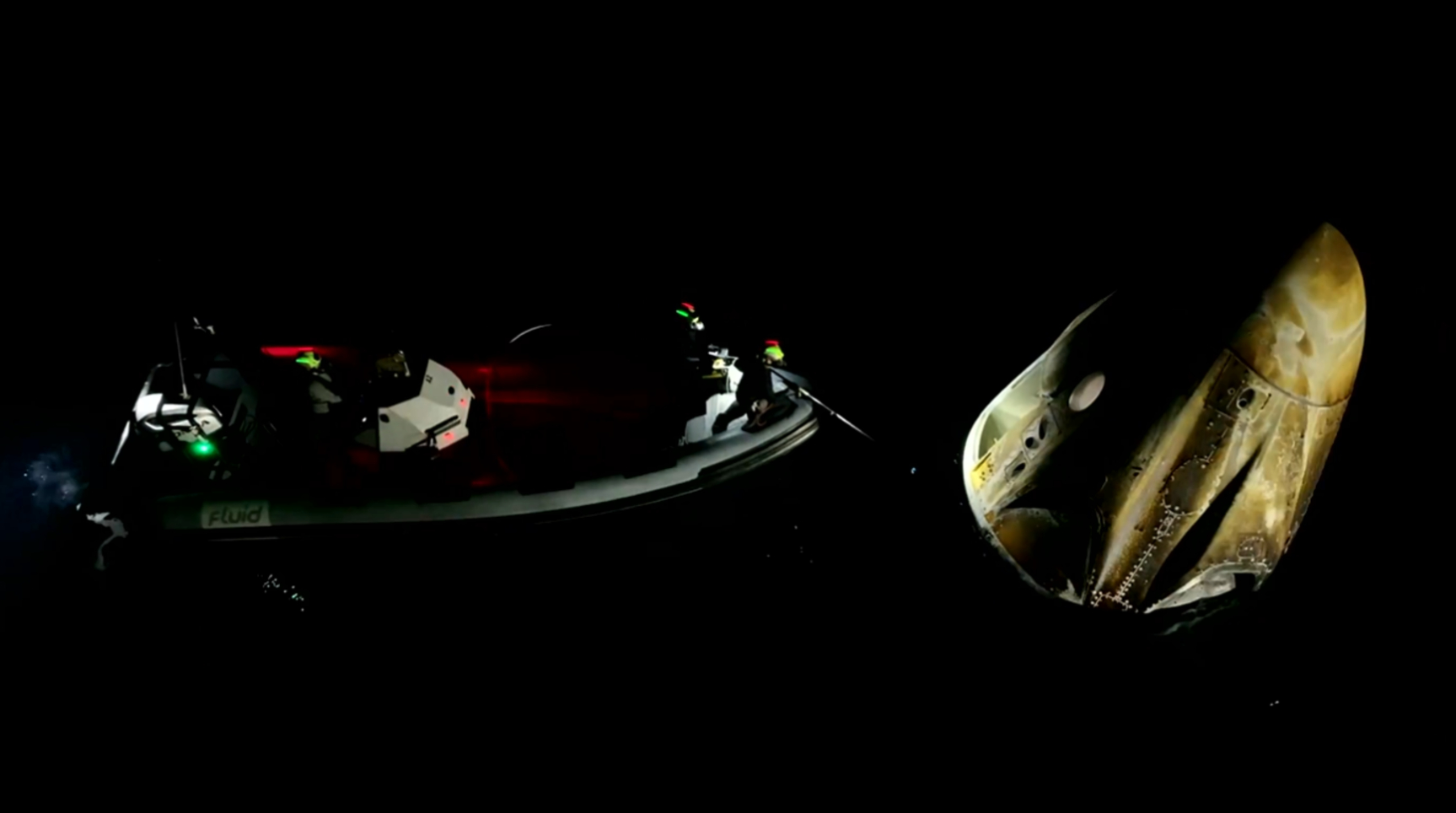 a boat on the left and AX 4 Dragon on the right during the recovery operations.