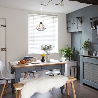 Grey and white kitchen with grey and wooden table with bench and chairs