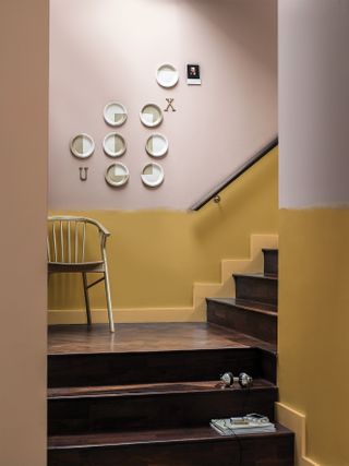 Wooden staircase with yellow wall below dado and neutral above