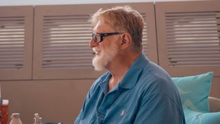 Extremely rich guy Gabe Newell smilng in profile, because he is an extremely rich guy doing extremely rich guy things