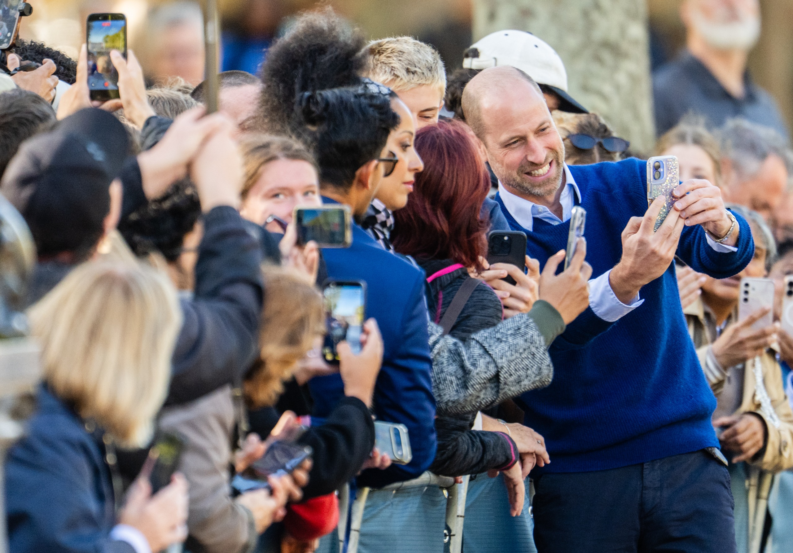 Prince William taking a selfie with a crowd of people