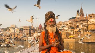 A Sadhu sitting on a boat in th ganges in varanasi, one of the best places to visit in india