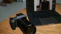 A Hasselblad camera next to a laptop with Capture One on the screen