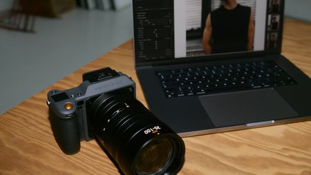 A Hasselblad camera next to a laptop with Capture One on the screen