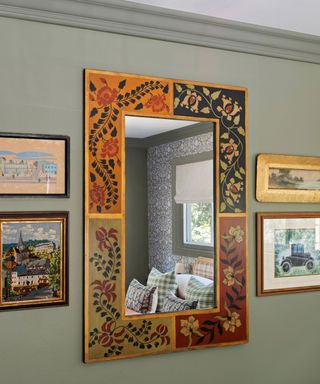 soft pale green wall with orange red decorative mirror