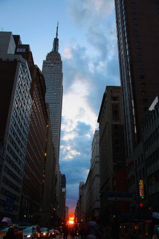 The Manhattanhenge sunset peered through the clouds on the cross streets of New York City. Photo taken on May 30, 2014.