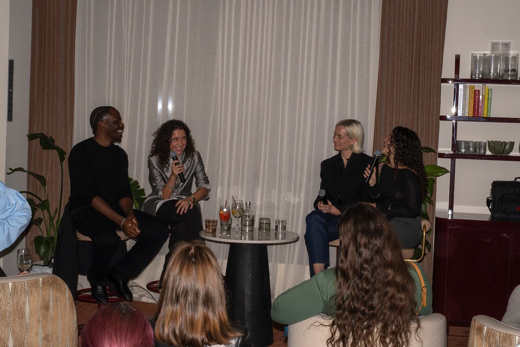 Event pictures showing a crowd mingling, eating food, and sipping drinks at a beautifully decorated bar with velvety surfaces, sculptural decor, and colorful bites.