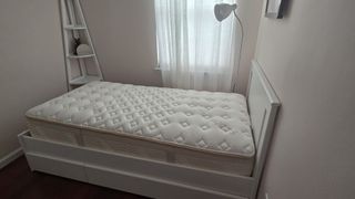 Saatva Memory Foam Hybrid Mattress on a white bed frame with headboard