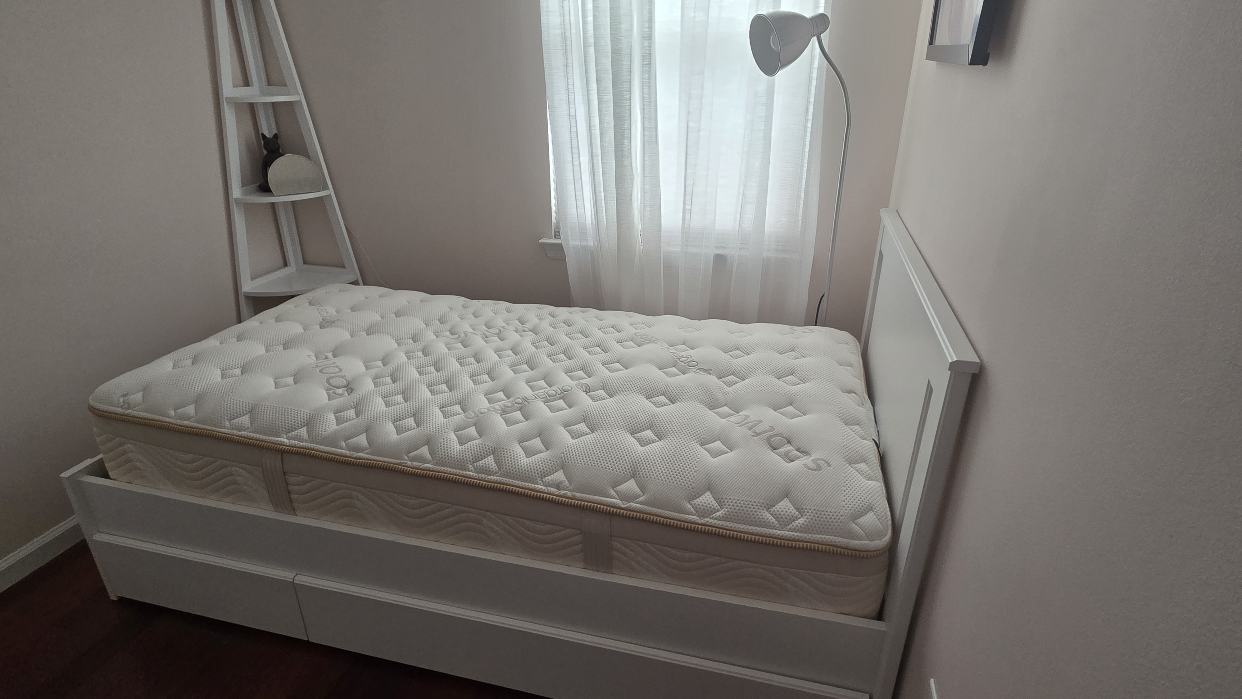 Saatva Memory Foam Hybrid Mattress on a white bed frame with headboard