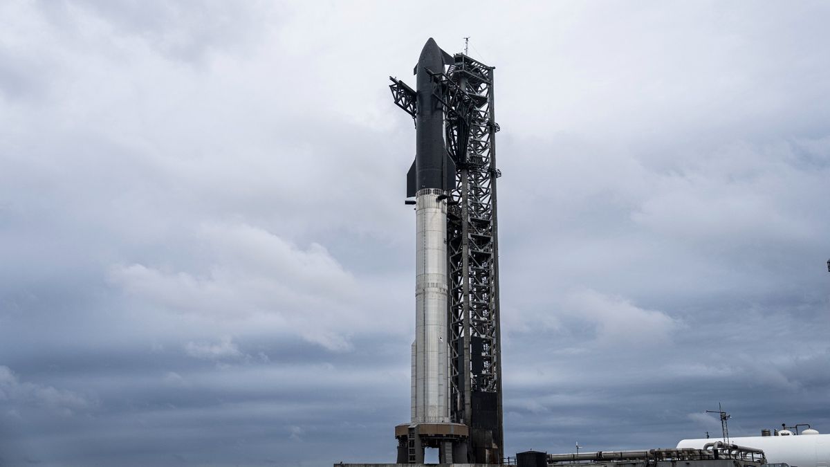 A silver stainless-steel SpaceX Starship is assembled for launch on the pad for Flight 7.