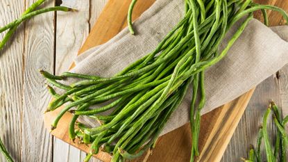 Raw yardlong beans on a wooden board